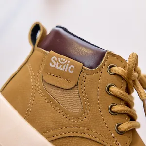 Close-up of kids yellow nubuck leather boots featuring SUIC logo and contrast stitching