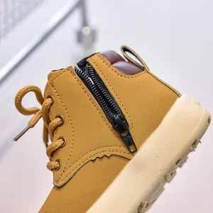 Detailed macro view of kids yellow martin boots with side zipper and matte leather texture