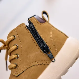 Close-up of yellow children's work boots showing side zipper and textured leather detail