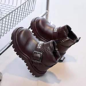 Close-up of children's leather boots with fashion buckle and durable rubber lug sole
