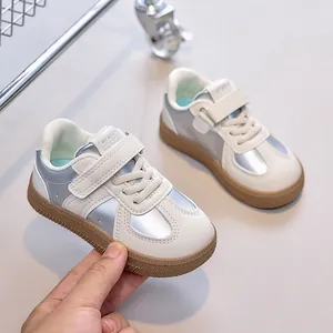 Détail de baskets pour enfants avec patchwork argenté, semelle gomme et scratchs