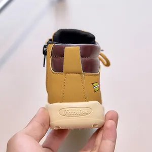 Detailed macro view of children yellow leather boots featuring durable fashion rubber sole