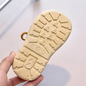 Detailed view of the yellow anti-slip rubber outsole for children boots with size 23 mark