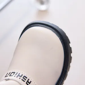 Close-up of cream leather kids boot with FASHION strap and rugged rubber sole