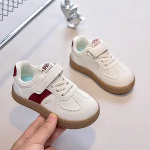 Détail de baskets blanches pour enfants avec bandes rouges et semelle en gomme antidérapante