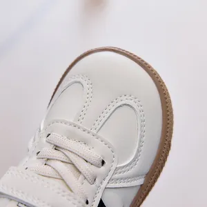 Détail de la tige en similicuir et des coutures fines sur les baskets d'enfant