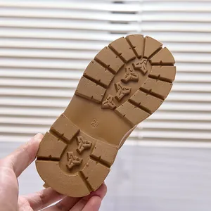 Close-up of durable brown anti-slip rubber sole with deep grip patterns for kids' boots