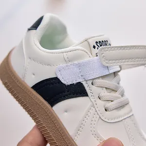 Détail d'une basket enfant montrant le cuir PU blanc et la semelle en caoutchouc souple