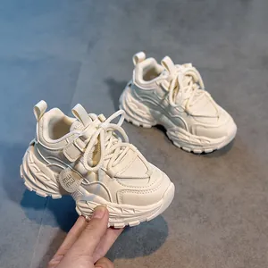 Vue détaillée des baskets beiges pour enfants avec velcro et design patchwork en cuir