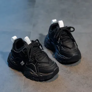Détail de baskets noires chunky avec empiècements en mesh multi-matières et lacets noirs