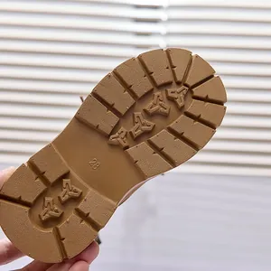 Detail view of non-slip rubber sole on brown kids boots with size 28 engraving