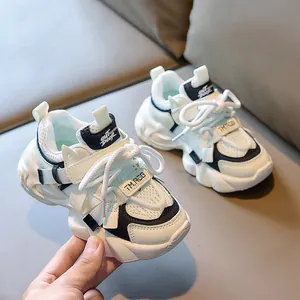 Detail view of breathable mesh and faux leather upper on children's black and white sneakers