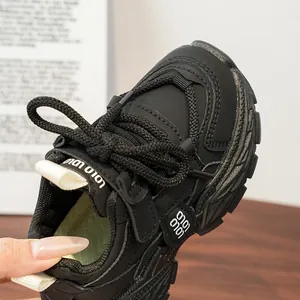 Detail of children's black dad shoes showing the mesh texture and LOLO velcro strap