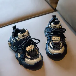 Detail of kids black and gold sneakers showing breathable mesh and non-slip thick sole