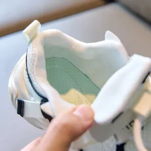 Detail of breathable mesh lining, pale green insole and heel pull tab of kids sneaker