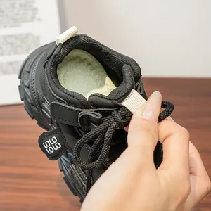 Detail of children's black sneakers with pull tabs and green plaid lining