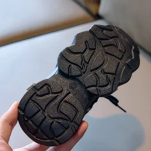 Detailed macro view of black non-slip rubber sole for children sports shoes size 28
