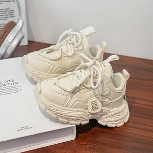 Close-up of cream chunky sneakers featuring thick rubber soles and layered leather texture