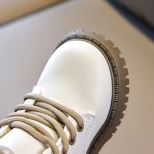 Detailed macro view of children's white leather boots showing stitching and durable rubber sole