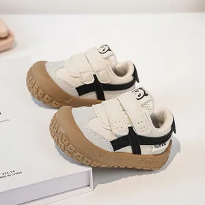 Detailed close-up of toddler walking shoes featuring dual velcro straps and panda motif