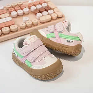 Close-up of pink and green toddler sneakers with double velcro straps and toe protection