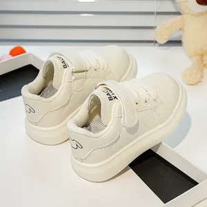 Détail de baskets blanches pour bambins avec velcro et motif de chiot mignon