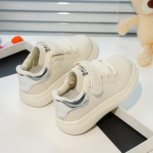 Vue détaillée des baskets blanches enfant avec talon argenté et fermeture à scratch