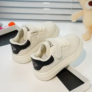 Détail de baskets blanches pour enfants avec velcro et motif d'ours sur le talon