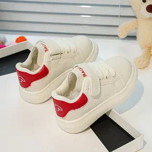 Détail de basket blanche pour enfant avec talon rouge et fermeture à scratch pratique
