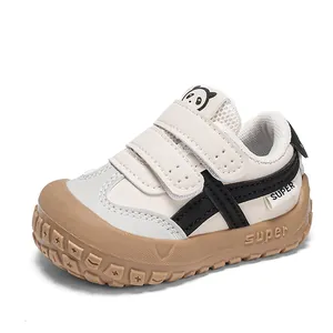 Detail of baby walking shoes with panda tongue and double Velcro straps in beige and brown