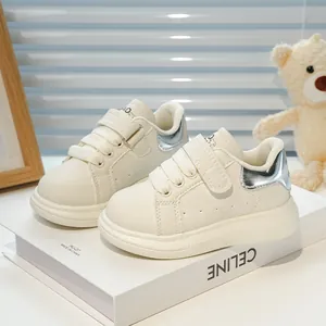 Détail de baskets enfant en cuir crème avec talon argenté et logo ours sur la languette
