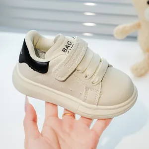Détail de baskets blanches pour enfants avec gaufrage latéral et sangles velcro mode
