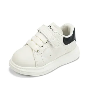 Baskets blanches pour enfants avec talon noir et velcro, vue de profil à 45 degrés