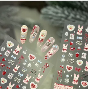 Close-up of Christmas nail stickers with cute rabbit, bow, and snowflake patterns