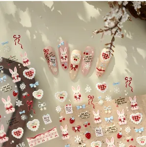 Macro detail of 3D embossed Christmas nail stickers featuring rabbits and red bows