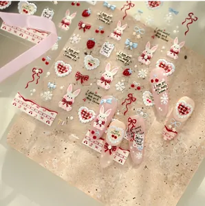 Detail of Christmas rabbit nail stickers with red bows, hearts, and snowflakes pattern