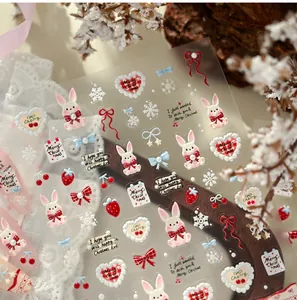 Detailed close-up of cute Christmas nail stickers with rabbit, strawberry and heart motifs
