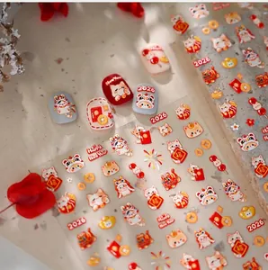 Détail d'autocollants nail art Nouvel An Chinois 2026 avec chats porte-bonheur et lingots