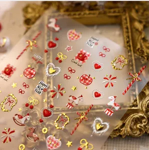 Close-up of 3D New Year nail stickers with gold horses, hearts, and candy cane patterns