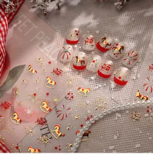 Detail of red and gold nail stickers featuring festive horses, stars, and fireworks