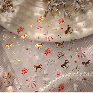 Detail of New Year nail decals with golden horse and stars on white manicured nails