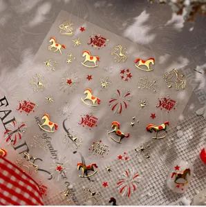 Detail of New Year nail art stickers featuring gold foil horses, stars and fireworks