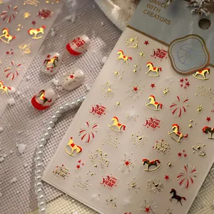 Macro view of New Year nail stickers featuring red and gold rocking horse and fireworks