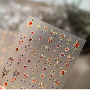 Macro detail of Chinese retro gold embroidery style nail art stickers with phoenix patterns