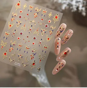 Detailed macro view of New Year nail stickers with golden phoenix and embroidery patterns