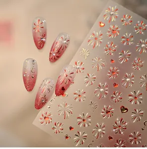 Detail of adhesive nail art stickers with red and gold firework and heart patterns