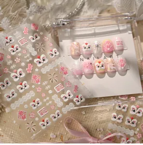 Detailed view of pink dancing lion nail stickers with 3D embossed floral patterns
