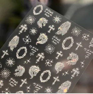 Macro shot of iridescent horse and gothic cross nail stickers with holographic effect