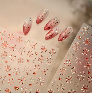 Macro detail of red and gold firework nail stickers with heart patterns for festive manicures