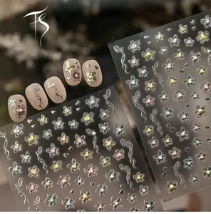 Macro view of floral embossed nail stickers with metallic flowers and 3D pearls